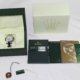 Rolex Daytona watch with original packaging, warranty booklet, and accessories displayed on a white surface.