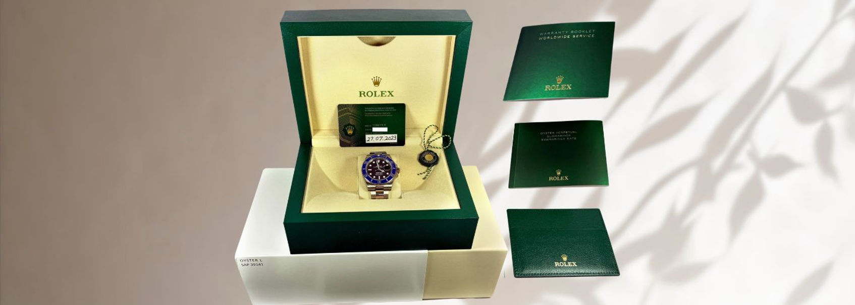 Rolex 'Cookie Monster' Submariner watch displayed in its original green box with warranty card and booklets, showcasing the blue and black bezel design.